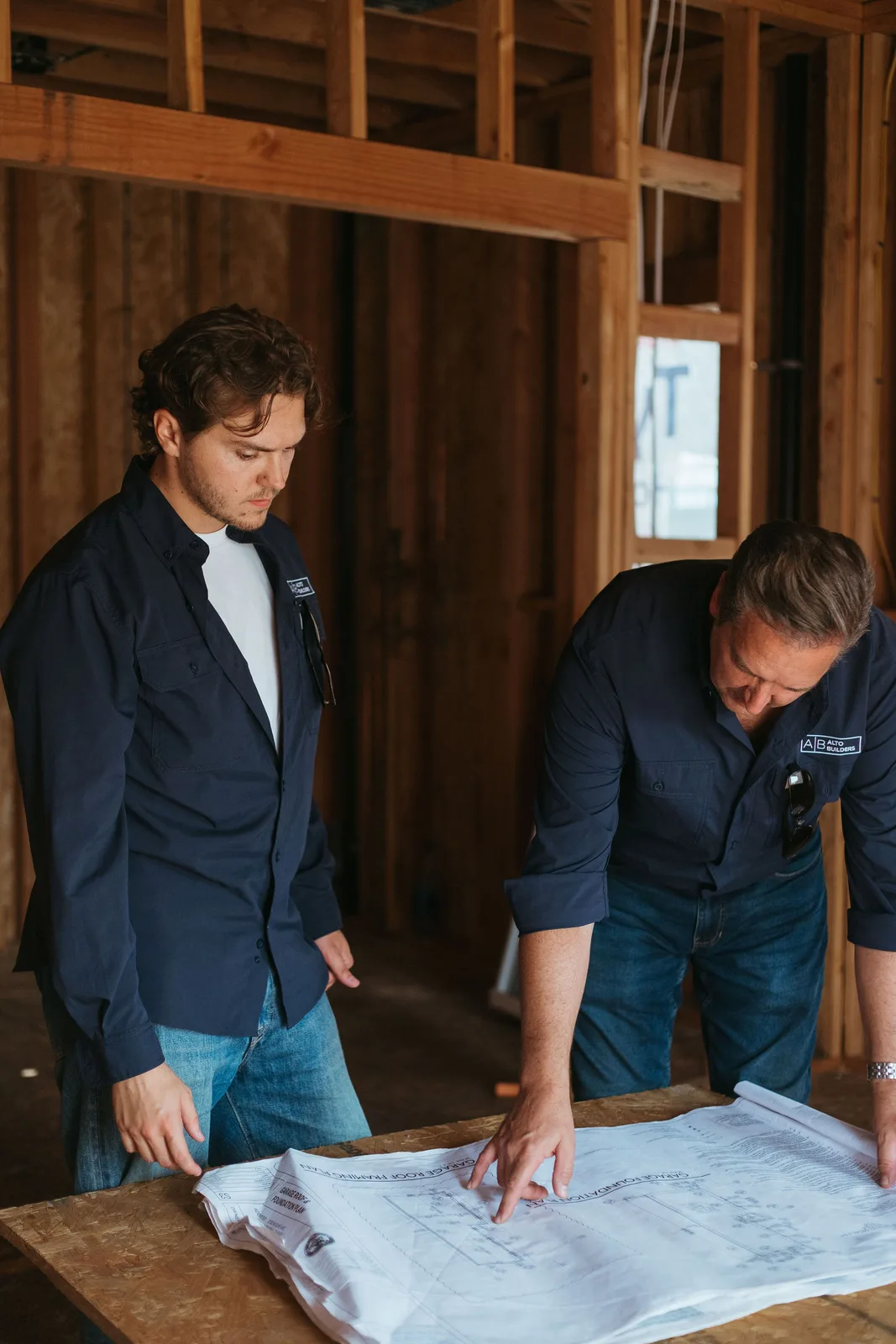 Reviewing blueprints inside a framed home