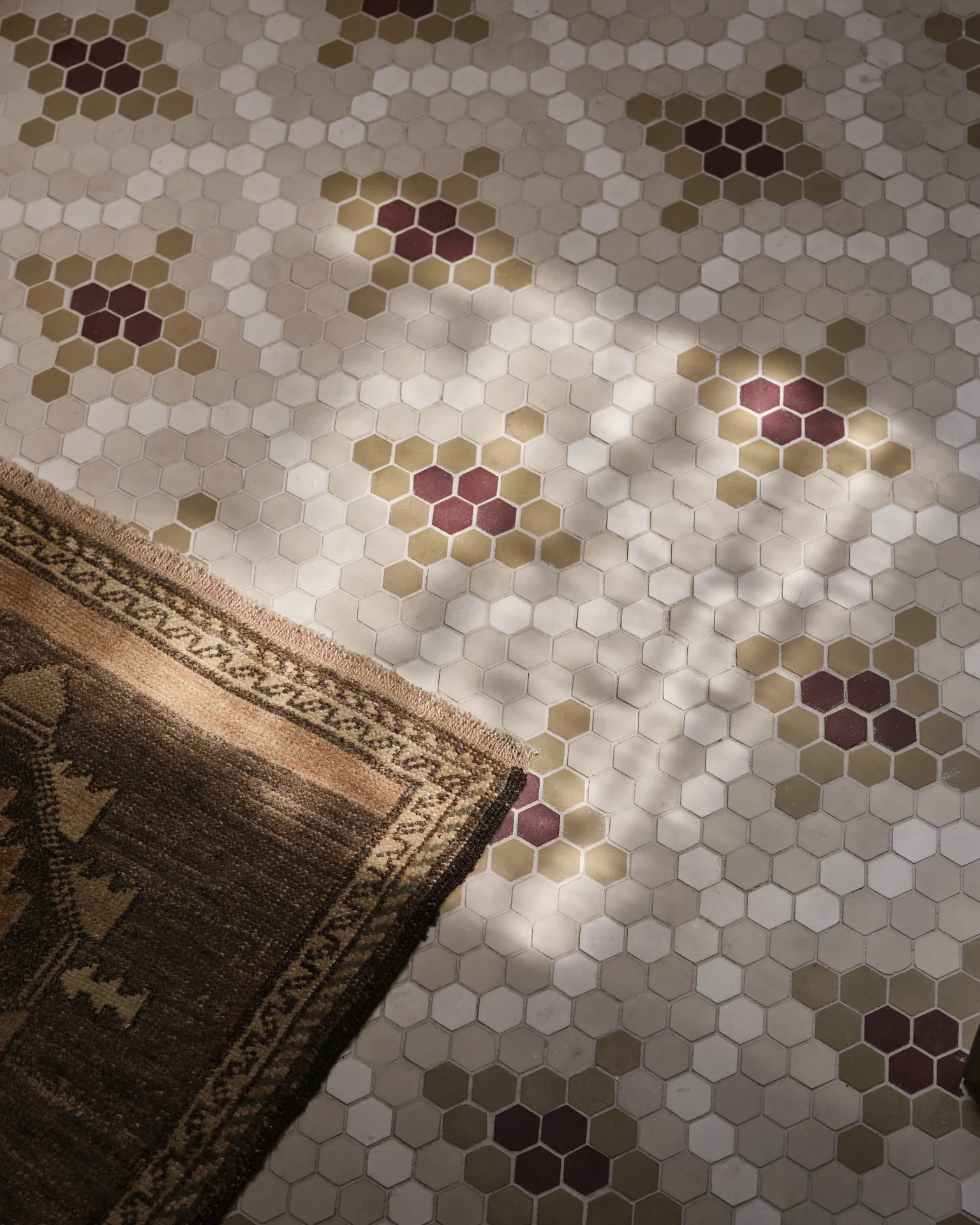 Hex mosaic bathroom floor with burgundy and olive accents