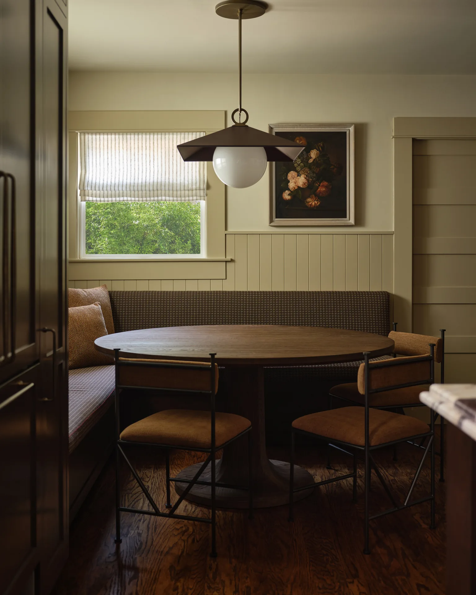 Built-in banquette dining nook under the original Craftsman windows
